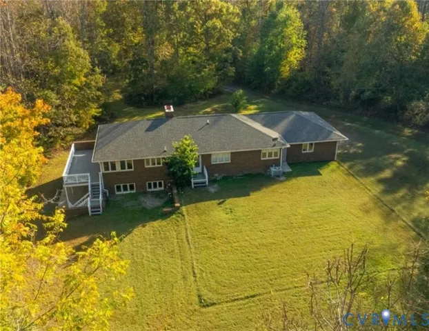 a aerial view of a house with swimming pool and large trees