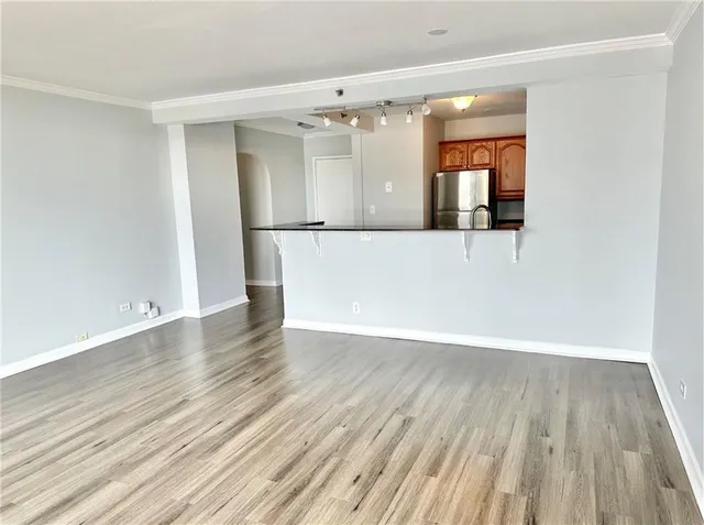 an empty room with wooden floor closet and windows
