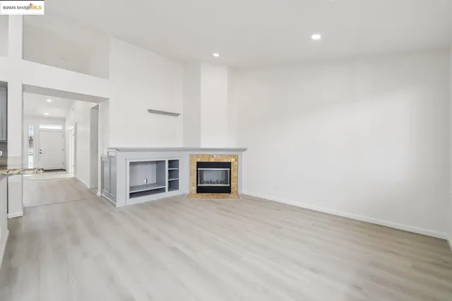 a view of an empty room with a fireplace and a window