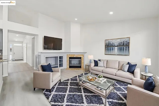 a living room with furniture a fireplace and a flat screen tv