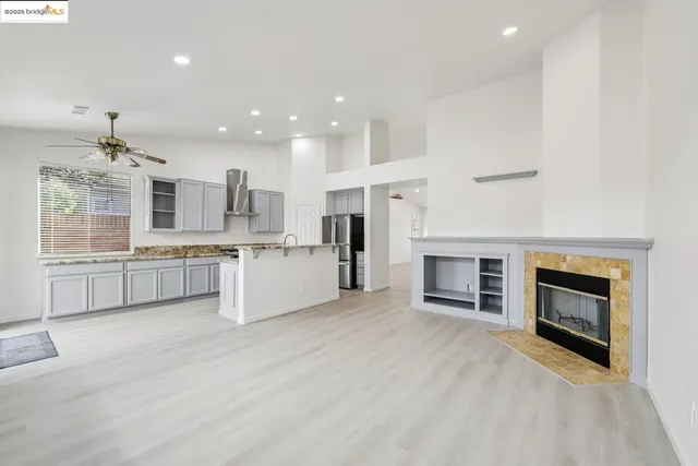a large white kitchen with a stove top oven and kitchen island