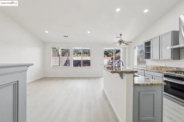 a view of a kitchen with granite countertop lots of counter top space and stainless steel appliances