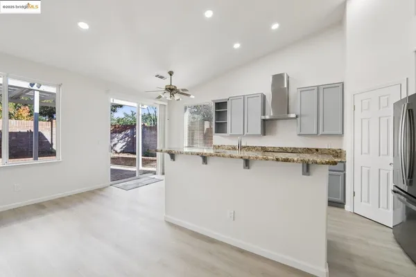 a large kitchen with kitchen island a sink a stove a refrigerator and white cabinets