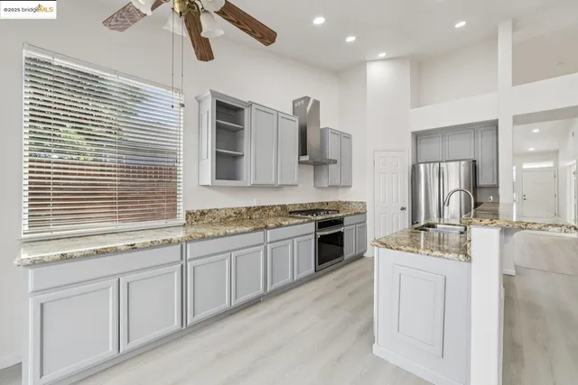 a kitchen with kitchen island granite countertop a sink stainless steel appliances and cabinets