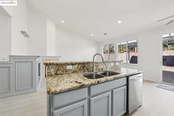 a kitchen with granite countertop a sink and cabinets