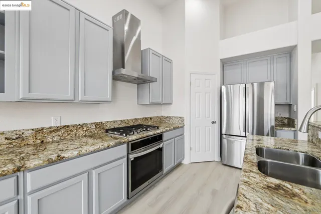a kitchen with stainless steel appliances granite countertop a stove and a refrigerator