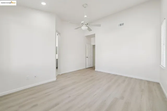 an empty room with an entryway and fan