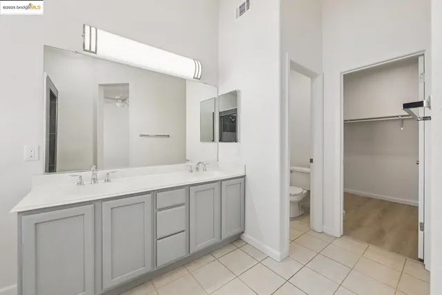 a spacious bathroom with a double vanity sink a mirror and a