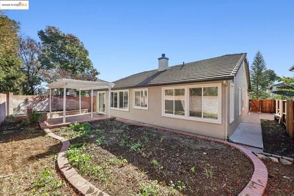 a view of a backyard with a patio and wooden fence