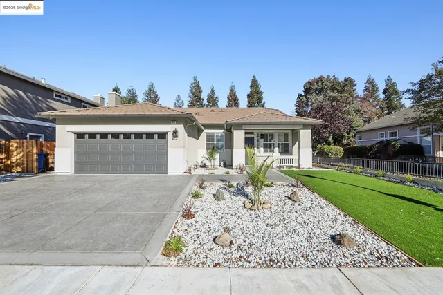 a front view of a house with a garden and yard