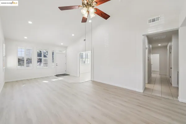 a view of an empty room with window and wooden floor