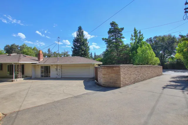 a patio with a table and chairs and potted plants