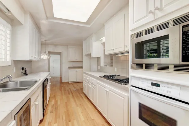 a kitchen with a sink stove top oven and cabinets