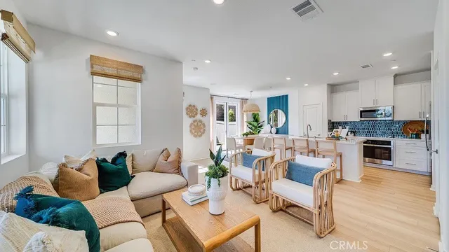 a living room with fireplace furniture and kitchen view