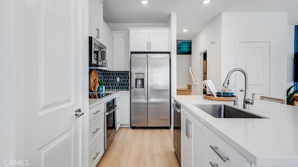 8475 Gabrielino Court Rancho Cucamonga, CA 91730 - Photo 4 of 19 a kitchen with stainless steel appliances a refrigerator sink and cabinets