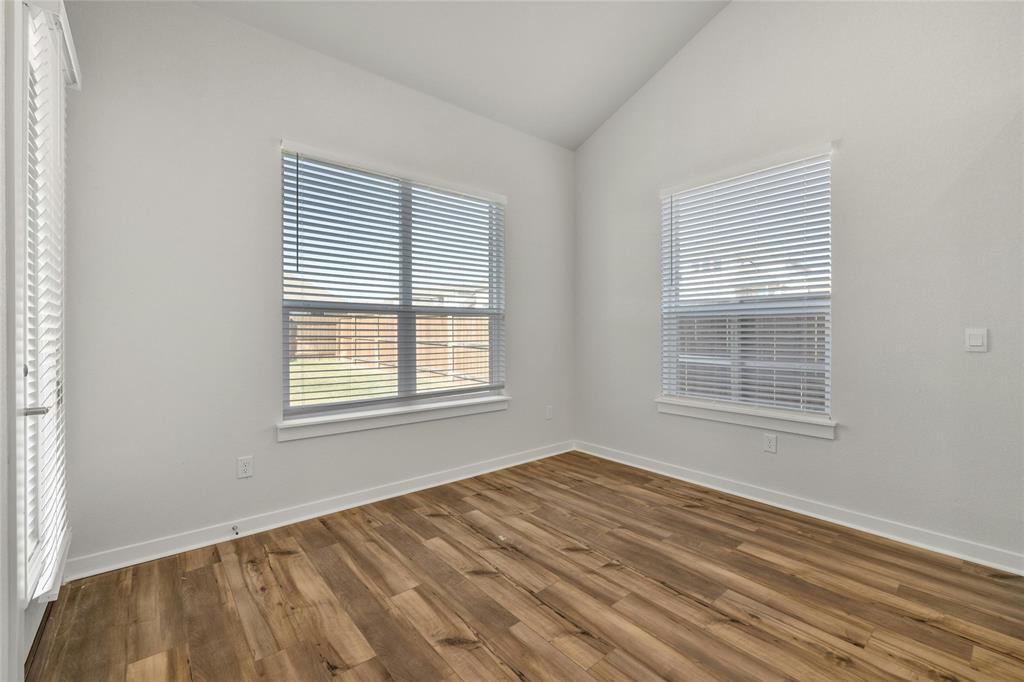 113 Shadow Oak Cove Georgetown, TX 78628 - Photo 14 of 40 A well-lit room showcases rich hardwood-style flooring and multiple windows with outdoor views.