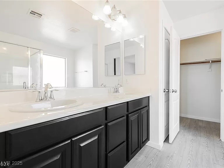 7600 Finishing Touch Court Las Vegas, NV 89149 - Photo 16 of 32 Bathroom featuring double vanity, light wood-style floors, and a walk in closet