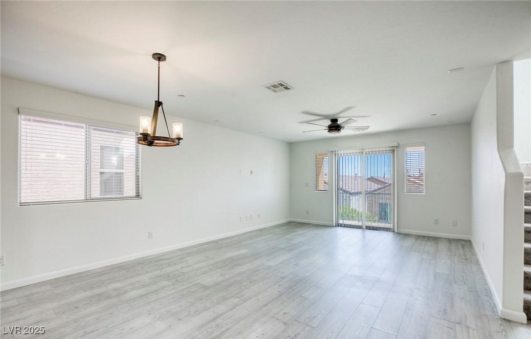7600 Finishing Touch Court Las Vegas, NV 89149 - Photo 19 of 32 Spare room with healthy amount of natural light, a chandelier, stairs, and light wood-style flooring