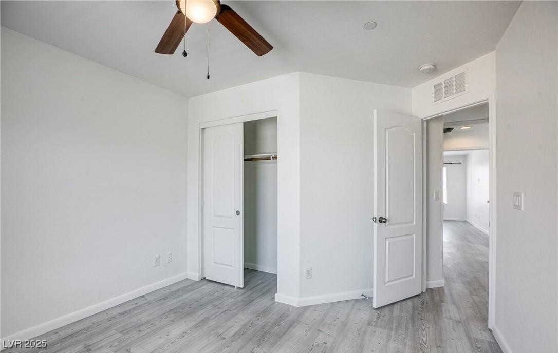 7600 Finishing Touch Court Las Vegas, NV 89149 - Photo 22 of 32 Unfurnished bedroom featuring light wood-style flooring, ceiling fan, and a closet