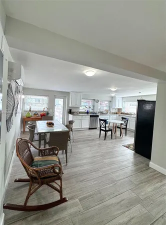 a living room with furniture a table and kitchen view