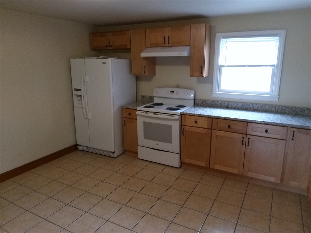 121 King Philip Road Worcester, MA 01606 - Photo 3 of 31 a kitchen with a stove a sink and a refrigerator
