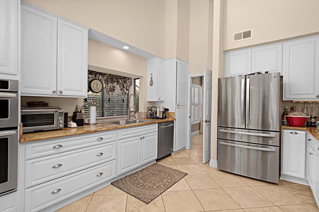 2046 Balboa Circle Vista, CA 92081 - Photo 20 of 37 a kitchen with granite countertop a refrigerator and a stove top oven