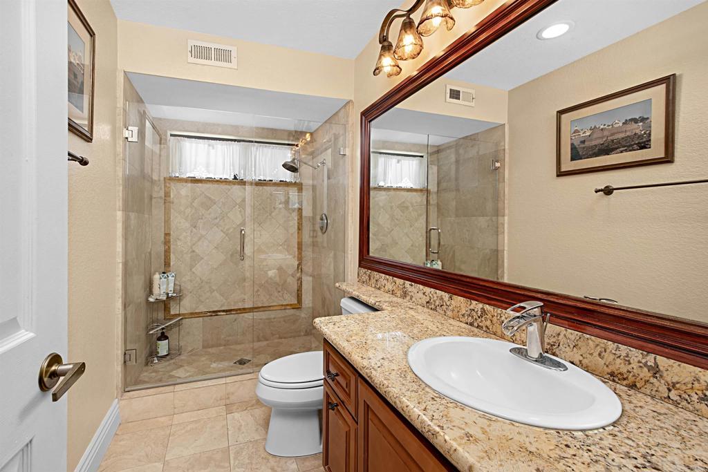 2046 Balboa Circle Vista, CA 92081 - Photo 24 of 37 a bathroom with a granite countertop sink toilet and shower