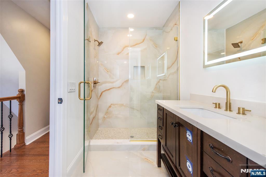 50 Grand Avenue Ridgefield Park, NJ 07660 - Photo 28 of 36 a bathroom with a granite countertop sink a shower and a mirror