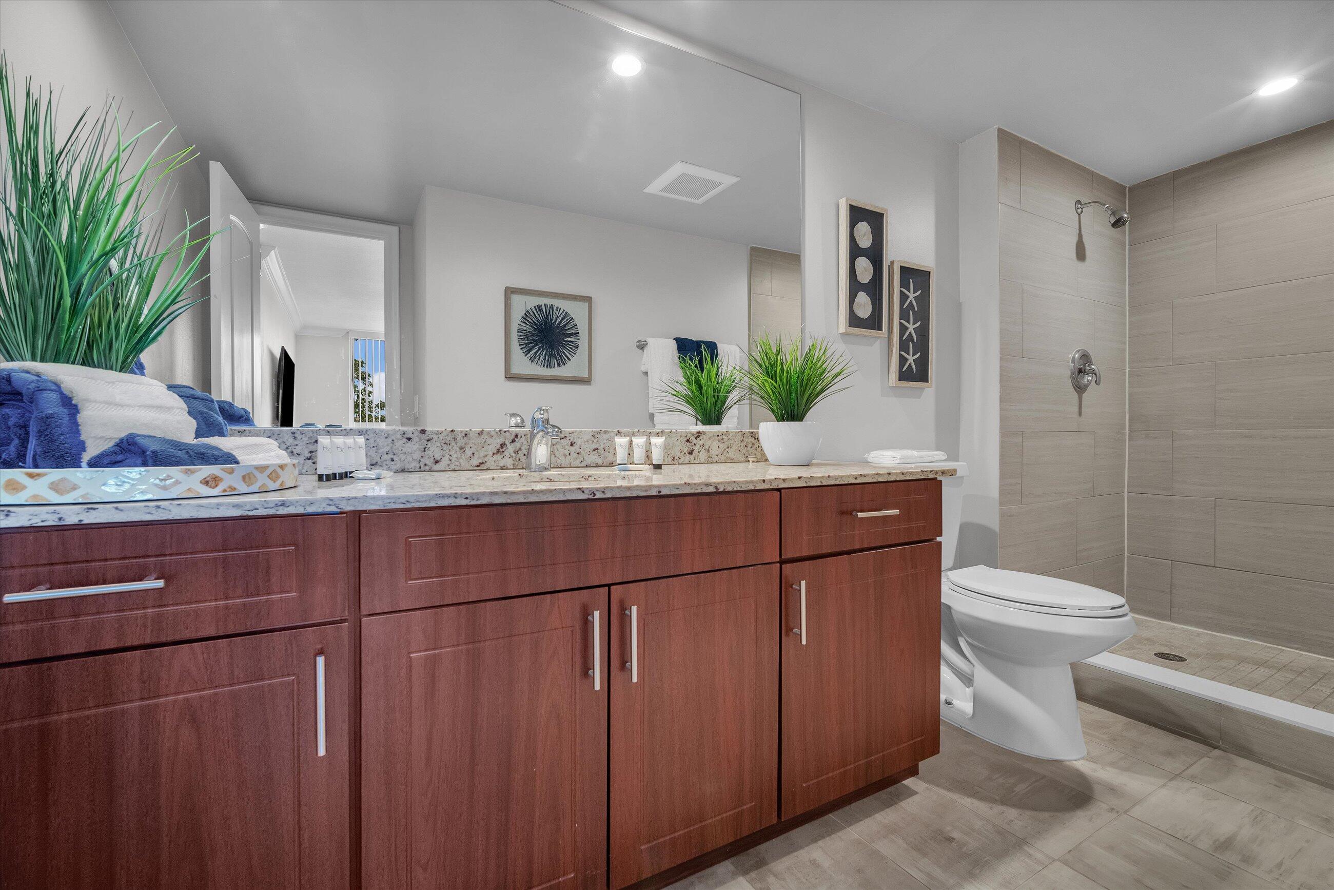 601 North Ocean Boulevard, Unit 203 Boca Raton, FL 33432 - Photo 17 of 20 a bathroom with a granite countertop sink a toilet and mirror