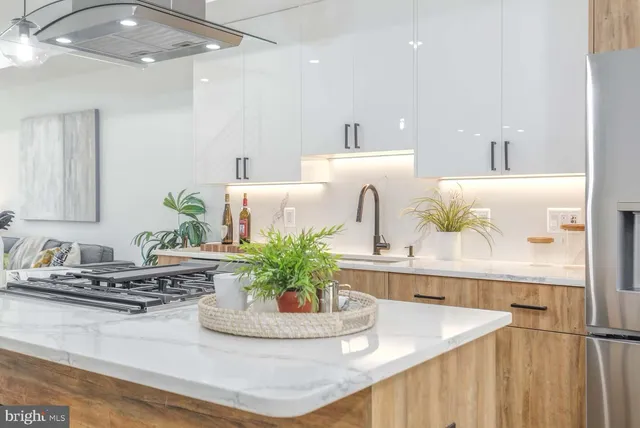 a kitchen with kitchen island granite countertop a sink and white cabinets