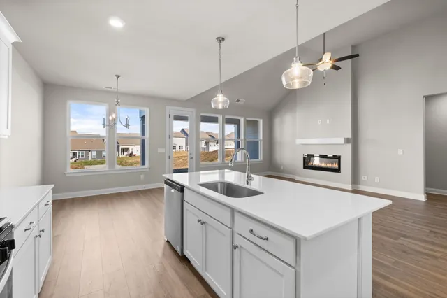 a kitchen with a sink stove and wooden floor