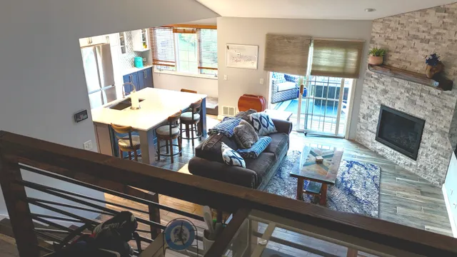 a living room with furniture a fireplace and a floor to ceiling window