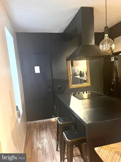 a view of a living room with a floor to ceiling window and wooden floor