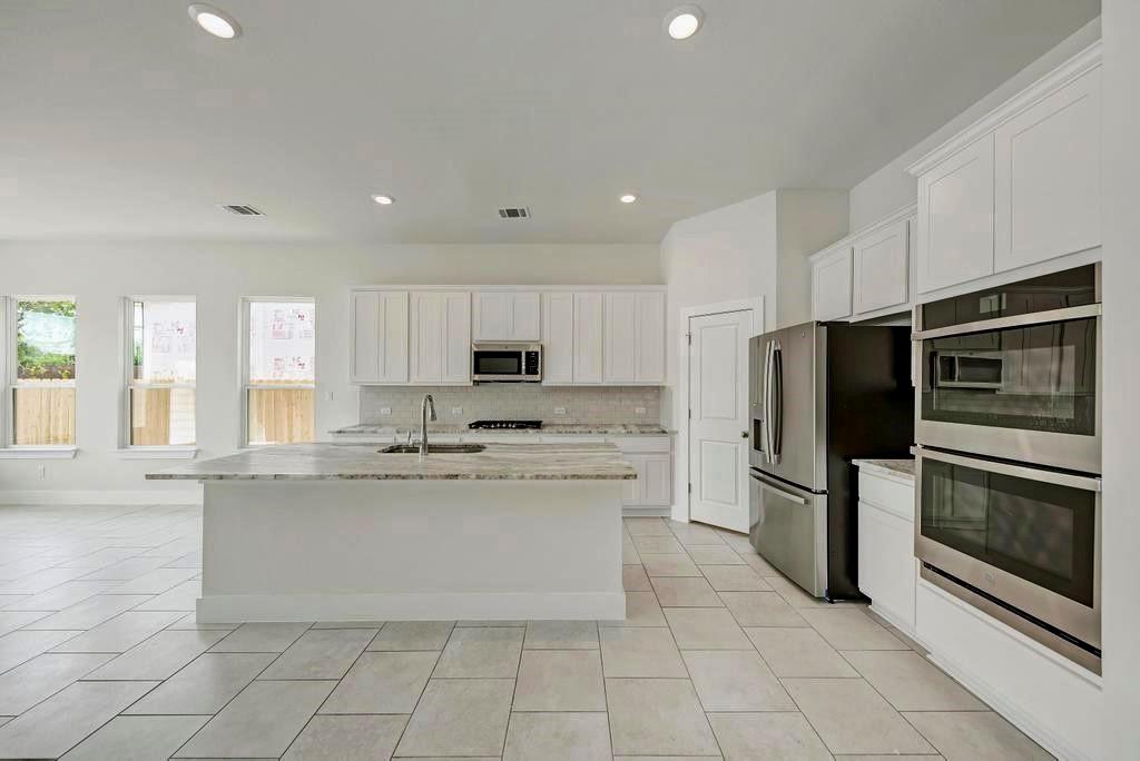 a kitchen with stainless steel appliances a refrigerator sink and microwave