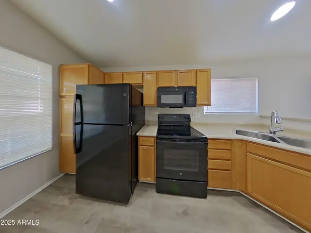 a kitchen with stainless steel appliances granite countertop a refrigerator sink and stove