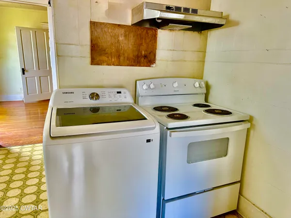 a view of a kitchen with stainless steel appliances granite countertop a stove and a wooden cabinets
