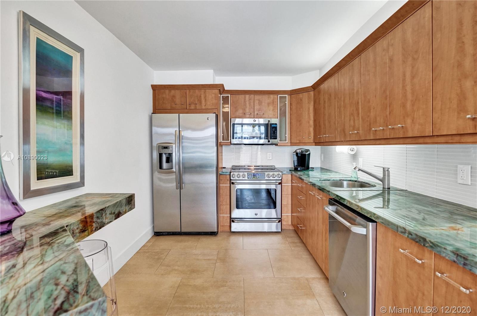 5750 Collins Avenue, Unit 15F Miami Beach, FL 33140 - Photo 14 of 65 a kitchen with stainless steel appliances granite countertop a refrigerator and a sink