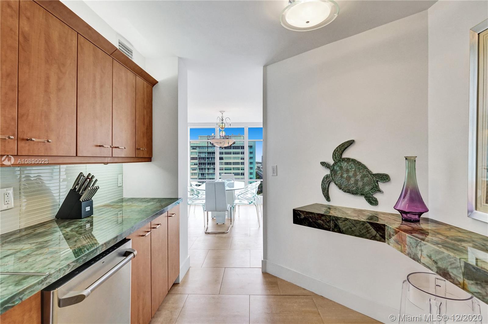 5750 Collins Avenue, Unit 15F Miami Beach, FL 33140 - Photo 26 of 65 a kitchen with granite countertop a sink a stove and cabinets