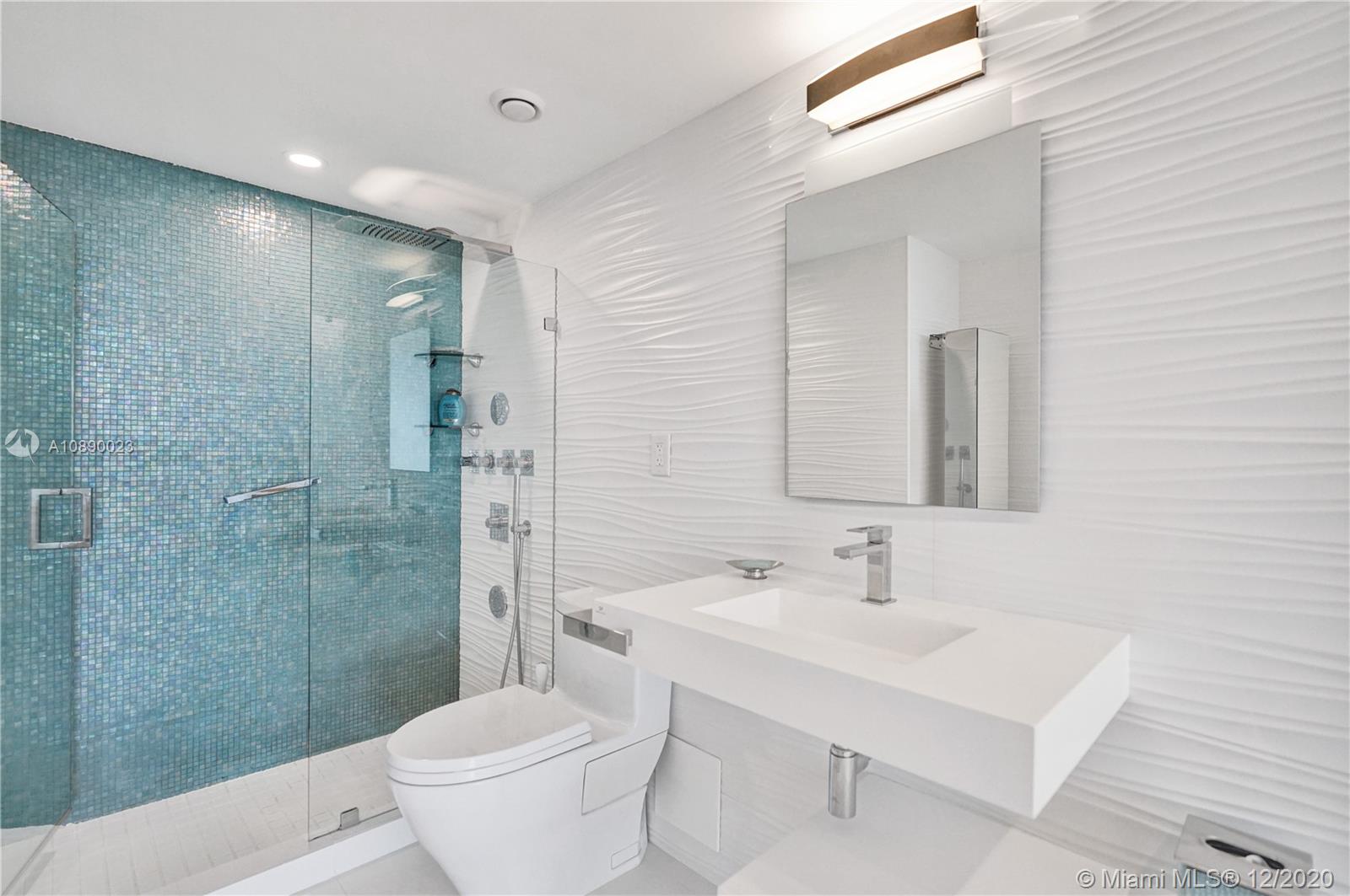 5750 Collins Avenue, Unit 15F Miami Beach, FL 33140 - Photo 42 of 65 a bathroom with a sink toilet a mirror and shower