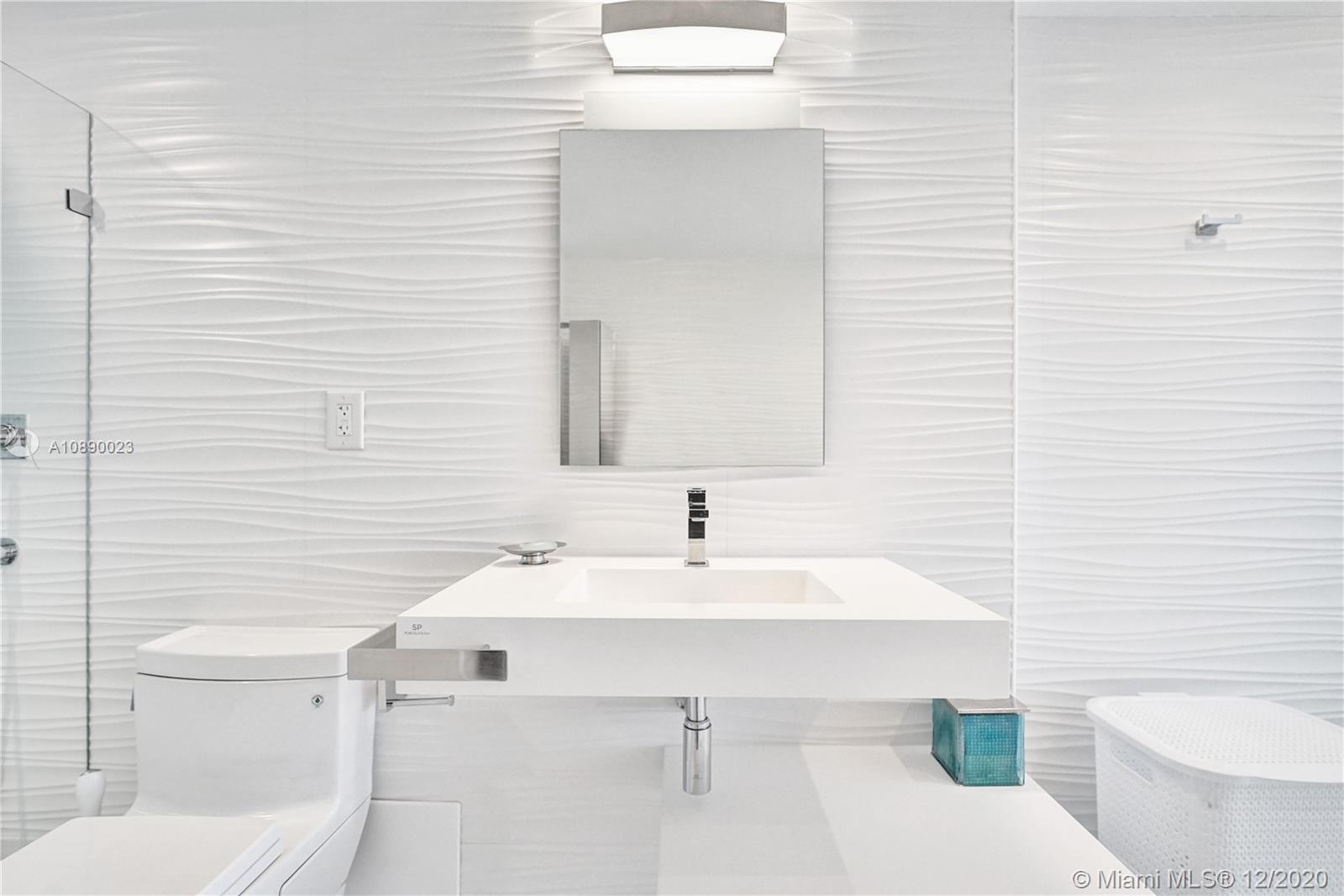 5750 Collins Avenue, Unit 15F Miami Beach, FL 33140 - Photo 44 of 65 a bathroom with a sink toilet and mirror