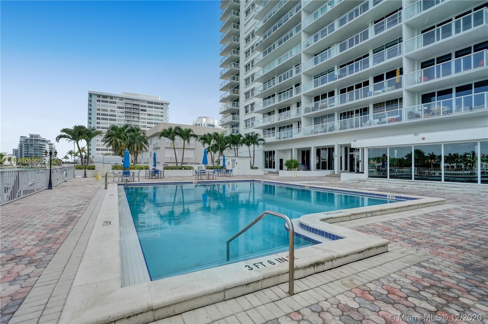 5750 Collins Avenue, Unit 15F Miami Beach, FL 33140 - Photo 59 of 65 a view of a swimming pool with a lounge chairs