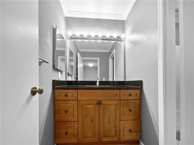 a bathroom with granite countertop a sink and a mirror
