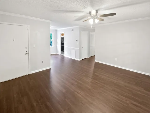 a view of an empty room with wooden floor