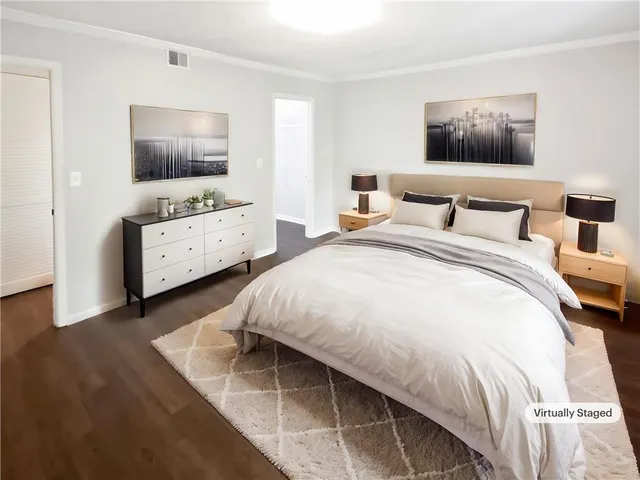 a bedroom with a bed and flat tv screen on the dresser
