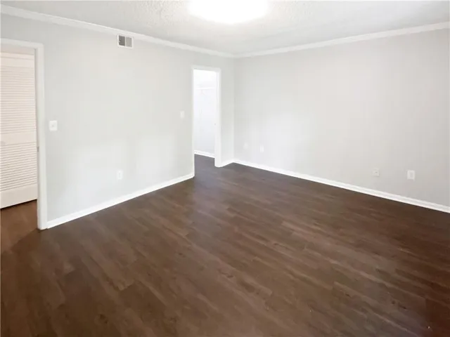a view of an empty room with wooden floor
