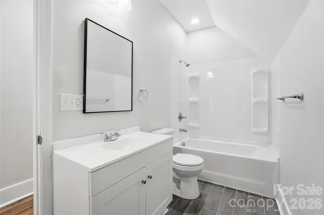 a bathroom with a bathtub shower sink vanity and toilet
