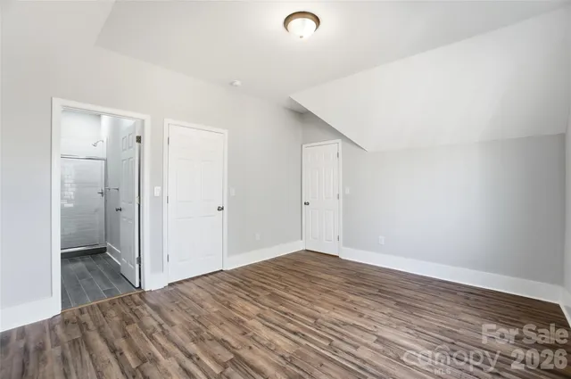 a view of a room with wooden floor and a bathroom