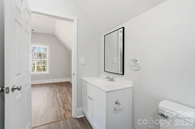 a bathroom with a sink a toilet and mirror