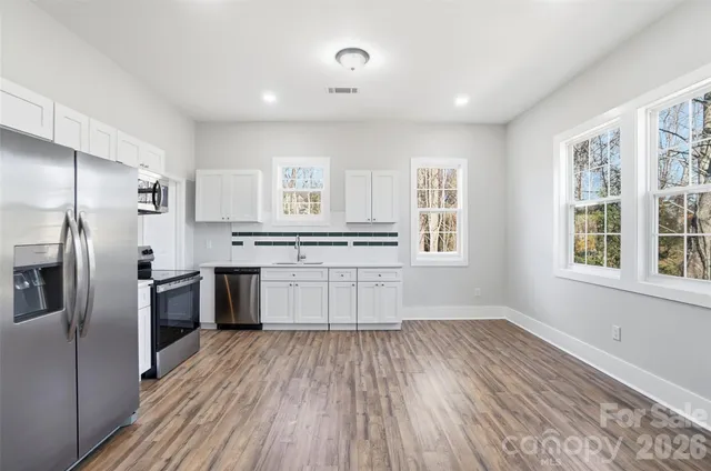 a kitchen with stainless steel appliances a refrigerator and a stove top oven