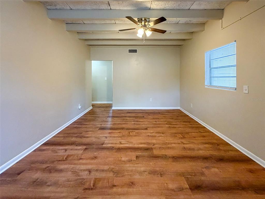 219 Northwest 3rd Avenue, Unit B Gainesville, FL 32601 - Photo 4 of 20 a view of empty room with wooden floor and fan